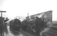 A busy scene alongside a wet platform 1 at Carlisle on 17 August 1963. Stanier Coronation Pacific 46244 <I>King George VI</I> is in the process of running through the station light engine, passing Royal Scot 46128 <I>The Lovat Scouts</I> waiting to relieve the locomotive off the 10.35am Blackpool - Perth / Edinburgh Princes Street. In the sidings to the right is station pilot 47515.<br><br>[K A Gray 17/08/1963]
