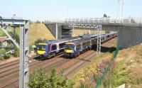 ScotRail services passing under the tram flyover at Saughton on 25 July. The 13.30 Glasgow Queen Street - Edinburgh Waverley (nearest) is slowing for the Haymarket stop, while the 13.47 Newcraighall - Glenrothes will soon be turning north towards the Forth Bridge.<br><br>[John Furnevel 25/07/2014]