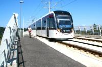 An eastbound tram passes a westbound bike on the flyover at Saughton on 25 July 2014.<br><br>[John Furnevel 25/07/2014]