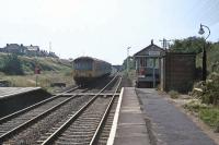 A shabby DMU toils out of Wrabness station in the exceptional heat of 15th August 1976, a time when air conditioning was something that happened only in the USA and the idea of buying bottled water was laughable. The jammed destination blind at the front half read <I>'Excursion'</I>, but the train was only going as far as Manningtree. Being a Sunday, Wrabness box (which ended up on the Colne Valley Railway post closure) is switched out.<br><br>[Mark Dufton 15/08/1976]