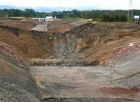 Demolition of the old A6106 road embankment between Shawfair and Sheriffhall well underway on 3 August 2014. View south from the new bridge that will carry the realigned road over the Borders Railway. The rail route under the City Bypass can be seen in the background, just to the left of the truck, which is about to negotiate the Sheriffhall roundabout. [See image 47993]<br><br>[John Furnevel 03/08/2014]