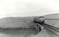 A St Combs - Fraserburgh DMU about to cross the Water of Philorth shortly after leaving Philorth Bridge Halt, thought to be in 1959. The branch closed completely in 1965 [see image 27116] [Ref query 12539]<br><br>[G H Robin collection by courtesy of the Mitchell Library, Glasgow //1959]