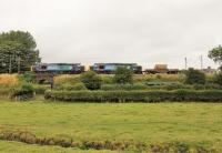 A single flask on the morning train from Crewe to Sellafield was an easy task for DRS EE Type 3s 37610 and 37402 on 1st August 2014. The train is approaching the Oubeck loops south of Lancaster, the trickle of water in the foreground being the Ou Beck from which the location gets its name. <br><br>[Mark Bartlett 01/08/2014]