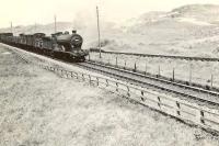 An up goods from Fraserburgh photographed passing Kirkton on 4 August 1953 behind 62469 <I>Glen Douglas</I>. The 4-4-0 had been reallocated from Eastfield to Kittybrewster some 4 months earlier. On the right the St Combs branch is starting to turn away towards the coast.<br><br>[G H Robin collection by courtesy of the Mitchell Library, Glasgow 04/08/1953]