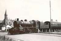 Watched by a small but attentive audience, Ivatt 2-6-0 no 46460 rumbles over Cairnbulg level crossing on 5 August 1953 with a St Combs - Fraserburgh train.   <br><br>[G H Robin collection by courtesy of the Mitchell Library, Glasgow 05/08/1953]