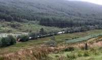 Just south of Glen Douglas a freight train for the Lochaber Smelter heads north through Glen Culanach. This glen is high above Loch long and to the south of the NATO depot. The lineside is treelined and further planting can be seen to the left of the locomotive.<br><br>[Ewan Crawford 16/08/2014]