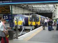 TransPennine Express 350401 prepares to depart platform 15 at Waverley with the 12.12 service to Manchester Airport. Standing alongside at platform 14 is ScotRail 334039 with the 12.21 service to Helensburgh Central.<br><br>[David Pesterfield /08/2014]