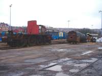 The wheeled chassis and cab of Black 5 44901 and the boiler and cab of 9F 92245 at the former Barry MPD in February 2013. The Black 5 boiler had been removed from site for use elsewhere. Left hand tender link tread plate still shows part of the for sale legend seen in the Peter Todd Feb 1986 view of the loco whilst in Barry scrapyard [See image 22739] <br><br>[David Pesterfield 11/02/2013]