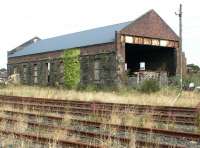 The locomotive shed at Stranraer, latterly BR code 68C, was officially closed at the end of October 1966. The site saw subsequent use as part of a scrapyard, during which time the main shed acquired a new roof. The building is seen here in May 2007, having been abandoned for a second time. [See image 45827]  <br><br>[John Furnevel 31/05/2007]