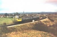 A Cravens Class 105 DMU climbs away from Farington Curve Junction to join the East Lancashire line on a service for Colne in 1978. These twin power car units were the staple motive power on this line for over 25 years. The embankment on the right once carried the direct services from East Lancs to Liverpool but finally closed in 1972. The field to the left of the train is now covered by housing.  <br><br>[Mark Bartlett //1978]