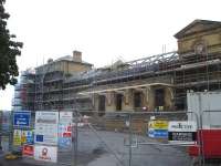 Slow progress on the restoration of Wakefield Kirkgate Station building, seen in this late August view. The east and west end multi storey structures and centre clock section appear to have now been re-roofed, with the single storey sections of the building still under restoration.<br><br>[David Pesterfield 25/08/2014]