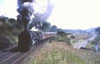 70002 <I>John Bunyan</I> climbing Neilston Bank unassisted with a 12 coach load on the approach to Neilston Low on 17 July 1965. Most heavy trains and expresses at the time took on pilot assistance as far as Kilmarnock, usually in the form of a Midland 2P 4-4-0.    <br><br>[John Robin 17/07/1965]