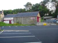 The former goods shed with extension at Llangefni station in July 2014. The High Street road overbridge is on the right. [See image 48500] <br><br>[David Pesterfield 23/07/2014]