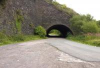 Slightly South and East of the former Abersychan and Talywain signalbox [see image 41491], the Eastern Valley line passed behind the top of the impressive retaining wall on the left. Just West of Pentrepiod halt, a branch dropped down to the North of the main line, and passed through this short wide tunnel - known locally as Big Arch, latterly used by road vehicles as well as rail. The branch served the British Iron Works, which closed in 1889; and Blaenserchan Colliery, which closed in 1985. View looks East.<br><br>[Ken Strachan 24/08/2014]