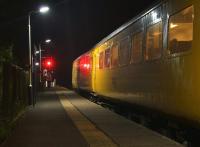 A Network Rail test train stands at Rufford late in the evening of 4 September 2014, held at the signal protecting the single line to Midge Hall. The wait was for the last service train to Ormskirk to arrive and surrender the single line electric key token. For the moment the signaller comes to collect the single line staff from the crew for the Ormskirk section.<br><br>[John McIntyre 04/09/2014]