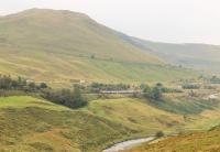 The Lune Gorge, with a <I>Virgin Super Voyager</I> heading north on a Euston to Glasgow (via Birmingham) service on 5 September. The train is passing Dillicar Common, although the famous Dillicar water troughs were some way north of this point. The M6, running on two levels, is close by the line here and the Tebay to Kendal road can be seen climbing across the hillside. <br><br>[Mark Bartlett 05/09/2014]