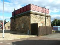 Rear view of the converted NER water tower adjacent to the car park on the north side of Haltwhistle station in September 2003. The former goods yard is off to the right and the main station entrance is in the left background. Since conversion, the 1861 structure has seen use as a shop, a cafe and a youth centre. [See image 28223]<br><br>[John Furnevel 21/09/2003]