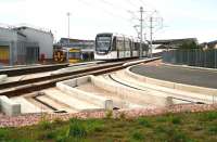 Back to the Future - Part 1b. An airport bound Edinburgh tram takes the bridge over Russell Road on 29 September 2014 as it runs past the north side of ScotRail's Haymarket TMD. The tram is approaching its next stop at Murrayfield, whose stadium dominates the background. In the foreground are the foundations for a possible future west to north link with tram route 1b (from the original Edinburgh Trams proposal) running north to Granton.<br><br>[John Furnevel 29/09/2014]