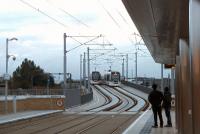 Evening scene at Murrayfield on 14 September as Tram 254 leaves for the airport, crossing a service for York Place on the Roseburn Street viaduct... to the <I>untrammelled</I> joy of the three passengers on the platform!<br><br>[Andrew Wilson 14/09/2014]
