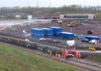 The first track-laying train on the Borders Railway - just before 10.00 on a dreich Monday 6th October, the Dutch track-laying train begins inching its way south from Newcraighall, propelled by a GB Railfreight Class 66. Track laying up to this point (with 60 ft rails) had been by means of cranes and other mobile equipment. Work on the new Edinburgh and Midlothian food waste recycling plant is underway on the far side of the line with Millerhill loco stabling point in the background.<br>
 <br>
<br><br>[David Spaven 06/10/2014]