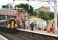 156462 boards passengers for Glasgow Central high level at Baillieston on 1st October 2014 as the rearrangement of platform furniture is finalised. [See image 48887]<br><br>[Colin McDonald 01/10/2014]