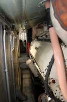 Taken from the mid point of the locomotive, this is the view towards the No.2 cab of <I>Deltic</I> alongside one of the two Napier 2-stroke engines. The low ceiling panels conceal the roof mounted water tanks feeding the steam heating boiler alongside the camera. In the confined space of the passageways on either side of the engines one could only sympathise with the travelling engineer who's working environment this was and speculate on the noise levels when the Napiers were under power.   <br><br>[Mark Bartlett 04/10/2014]