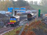Early morning at the north end of Millerhill Yard on 9 October 2014. Nearest the camera is DRS 66302, while just beyond is GBRf 66706 preparing to move off south along the Borders Railway with the tracklaying train. <br><br>[John Furnevel 09/10/2014]