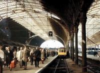 Saturday morning at Paddington on 29 March 1969. Passengers are heading for the concourse off a train from Plymouth which has recently arrived at platform 6 behind D1007 <I>Western Talisman</I>. Meantime, alongside at platform 7, a Reading line DMU stopping service is slowly approaching the buffer stops.<br><br>[John Furnevel 29/03/1969]