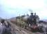 NBR 256 <I>Glen Douglas</I> with <I>Scottish Rambler no 3</I> during a photostop at Drumshoreland station on 30 March 1964. Originally opened as Broxburn in 1849 the name change occurred in 1870. The station, which closed to passengers in 1951, was located in the shale mining centre of West Lothian, signs of which can be seen on both sides of the picture. <br><br>[John Robin 30/03/1964]
