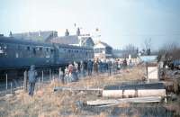 After Ramsbottom closed to passengers in 1972 the Up Platform was completely removed. By February 1981, when the <I>Rossendale Farewell Railtour</I> ran to mark full closure, the area had become something of an eyesore. The 6-car DMU is seen here waiting for the level crossing gates to be opened before continuing to Rawtenstall. [See image 21820] for an ELR era view with the now reinstated platform and footbridge. <br><br>[Mark Bartlett 14/02/1981]