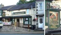 A view of the J.W.Lees pub <I>The Railway</I>, sited opposite the entrance to the former Llangefni station. Alongside is a blown up version of the pub sign - possibly featuring a crimson Jubilee (?) [See image 24625] <br><br>[David Pesterfield 23/07/2014]