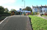 The 1352 service to Birmingham International arrives at Criccieth on 14th October 2014. The infilled bay platform gives access to a small garden, while the remains of the old down platform stand in the undergrowth on the left. [See image 49207] [Ref query 15789]<br><br>[Colin McDonald 14/10/2014]