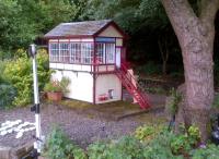 That's either a very large tree, or a very small signal box. This is the strictly one-man Stapleford Junction box on the Stapleford Miniature Railway, in June 2014.<br><br>[Ken Strachan 28/06/2014]