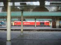 Grab shot from a Barry Island service departing from Cardiff Central on 30 October, showing refurbished DB Schenker 60024 heading slowly east through the station with a heavy consist of steel slab.<br><br>[David Pesterfield 30/10/2014]