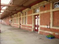 A view behind fencing along most of the platform side wall and full length canopy at the former Barry Island station building in October 2014. The building is now mostly occupied by Cambrian Transport, who operate the Barry Tourist Railway. There is also a caf and military museum located just off picture to the right.<br><br>[David Pesterfield 30/10/2014]