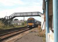 A late morning Edinburgh - Dundee service runs through the deserted platforms of Errol station (closed September 1985) in the Carse of Gowrie on 4 September 2006. Photograph taken leaning (carefully) over the verandah fence of the tea rooms occupying the 1847 station building on the right.<br><br>[John Furnevel 04/09/2006]