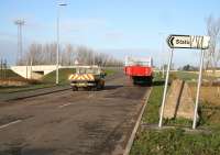 Early casualty? The <I>'modified'</I> road sign pointing west into the under-construction Shawfair station and car park on 10 November 2014. The innocent looking red flatbed trailer contains a section of the ramp for the new station footbridge.<br><br>[John Furnevel 10/11/2014]