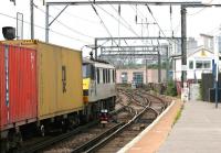 Freightliner 90044 runs west through Camden Road station on the North London Line with a container train from Felixstowe in the summer of 2005. The route is set for the direct freight only line which joins the WCML just east of Primrose Hill Tunnel [see image 53461] where the train will head north towards Manchester and its ultimate destination at Trafford Park FLT. The route to the right just beyond Camden Road Junction box is the NLL route to Richmond via Gospel Oak and Willesden Junction High Level.<br><br>[John Furnevel 21/07/2005]