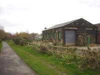 Looking east towards Penistone station in November 2014 along the Trans Pennine Trail, that runs along a narrowed strip of the Woodhead route trackbed until, some 50 metres behind camera, it then widens out to utilise the full width of the old trackbed. The old goods shed stands on the right, with coal drops beyond to its left.<br><br>[David Pesterfield 13/11/2014]