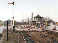 Looking west over the level crossing from Kingsknowe Station around 1980 with the brake van of a freight train disappearing into the distance.  Engineers wagons occupy the sidings on the right.<br><br>[Bill Roberton //1980]