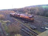 The driver of 66007+66102 proceeds slowly into the forest purporting to be the east end of Healey Mills Marshalling Yard to recover a long stored former National Power bogie wagon for road movement to a Marcroft depot for refurbishing.<br><br>[David Pesterfield 17/11/2014]