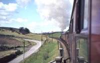 The SLS/BLS Scottish Rambler No 2 has just passed through the site of Buittle station (1859-1894), heading west, behind Jubilee 45588 <I>Kashmir</I>. The wayside station (pronounced <I>'Bittle'</I>) between Dalbeattie and Castle Douglas was closed early in the railway's history when the line was doubled. The old station entrance can be seen to the left of the road on 15 April 1963. [Ref query 6890]<br><br>[John Robin 15/04/1963]