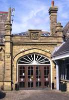 The south side entrance to Morecambe Promenade station in August 2014, with the initials of the Midland Railway carved in the stonework above the door. It's a pity that the attention to detail apparent in the early 20th century building was not perpetuated in the recent extension on the right - note the flashing where the new roof meets the original wall! <br><br>[Bill Jamieson 07/08/2014]