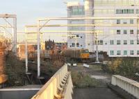 Looking down the disused roads at Salford Central on 2 December, standing by the new lift to the surviving westbound platform. An MPV on RHTT duties is passing under the new gantries on the Ordsall line. The station concourse is on the main road directly below the three rail bridges [See image 32857].<br><br>[Mark Bartlett 02/12/2014]