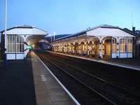 View east through Hexham station, showing no material change in the platform structures from that of 50 plus years ago, apart from the modern high output lighting. The figure awaiting the 16.15 departure to Middlesbrough appears to be an alien, with a green beacon where the head would normally be.   <br><br>[David Pesterfield 03/12/2014]