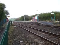 Kidwelly Station looking west from the entrance to the down platform entry path alongside the level crossing in October 2012. There is vehicle access to the up platform entrance gate. The signal box is behind the camera. The up waiting shelter offered no protection from a torrential downpour propelled by a gale force wind from the south. Standing behind was little better.<br><br>[David Pesterfield 31/10/2012]