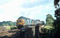 Two Lickey bankers, EE Type 3s 37158 and 37204, giving much needed assistance to 47307 and its long train of tank wagons on the 1:37 Lickey Incline in 1980 [see image 49924]. The summit at Blackwell is alongside the houses that can be seen above the tanks. There the bankers will drop off and return to Bromsgrove.  <br><br>[Mark Bartlett 11/09/1980]