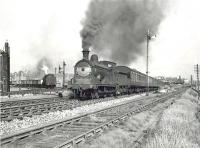 Ex-Caledonian 0-6-0 no 57554 making a smoky departure from Partick West station on 2 August 1957 at the head of a Rutherglen - Balloch service. The train is about to pass Partick West Junction. In the background a westbound freight is held at signals on the approach line from Partick North Junction.<br><br>[G H Robin collection by courtesy of the Mitchell Library, Glasgow 02/08/1957]