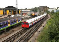 A Bakerloo line train for Harrow and Wealdstone passing Willesden Traincare Centre in July 2005. Virgin 'Thunderbird' no 57311 <I>Parker</I> stands in the background.<br><br>[John Furnevel 20/07/2005]