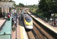 The West London Line platforms at West Brompton looking south from Old Brompton Road in July 2005. Passengers awaiting a Watford - Brighton train on platform 3 stand well back (apart from one eejit) as a 'eurostar' runs through empty on its way from North Pole to Waterloo. A District line train from Wimbledon has recently arrived at platform 2. [See image 37756]<br><br>[John Furnevel 22/07/2005]